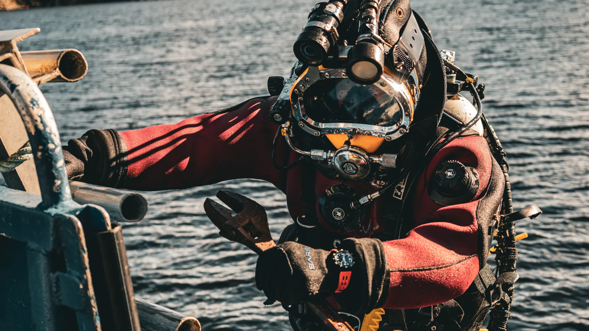 Commercial Diver Watch Features That Matter 1 A commercial diver in a Kirby Morgan helmet climbing aboard a dive boat, wearing an Aquastar Benthos Professional