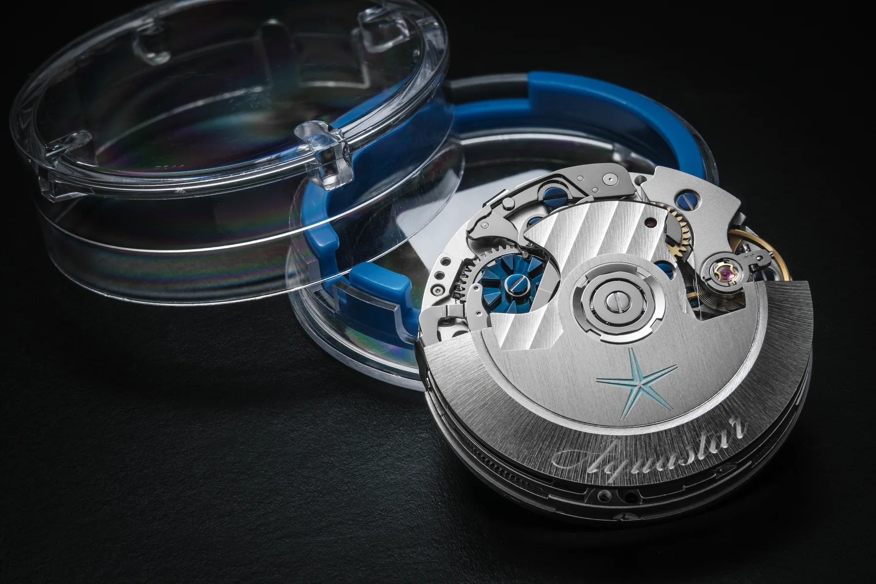 Swiss Watch Movements: ETA, Sellita, La Joux-Perret 1 An Aquastar chronograph movement resting beside its clear case back